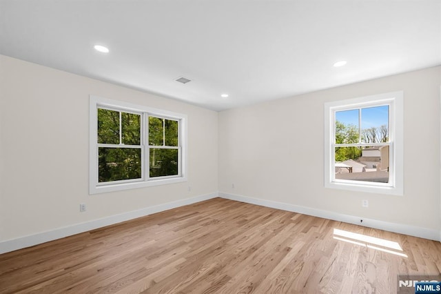 empty room with baseboards, visible vents, and plenty of natural light