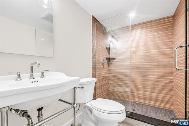 full bathroom featuring toilet and a stall shower