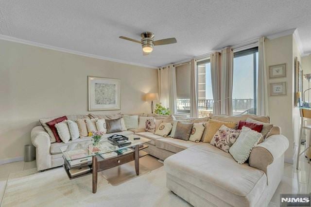 living area featuring baseboards, ornamental molding, a textured ceiling, and a ceiling fan