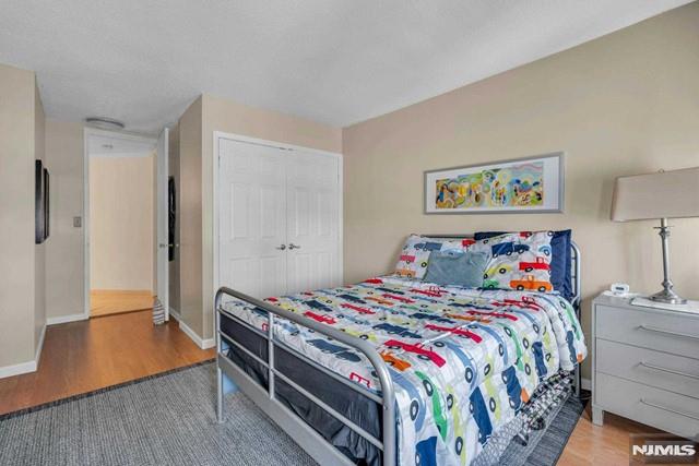 bedroom with a closet, baseboards, and wood finished floors