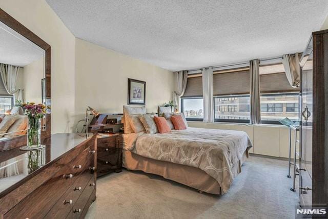 bedroom featuring a textured ceiling, multiple windows, and light carpet