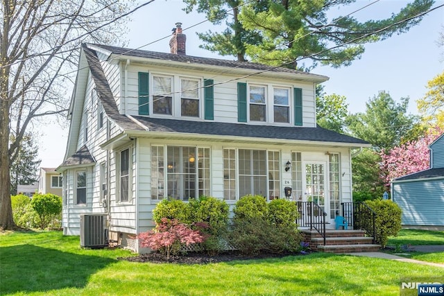 view of front facade with a front lawn, central AC, and a chimney