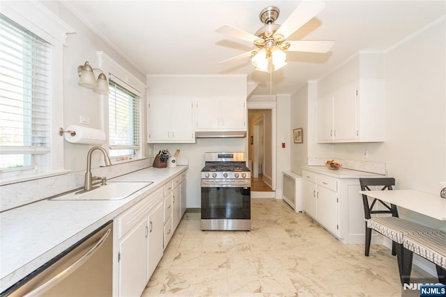 kitchen with light countertops, stainless steel appliances, white cabinetry, and a sink