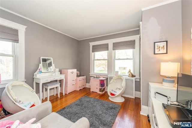 rec room featuring crown molding, baseboards, and wood finished floors