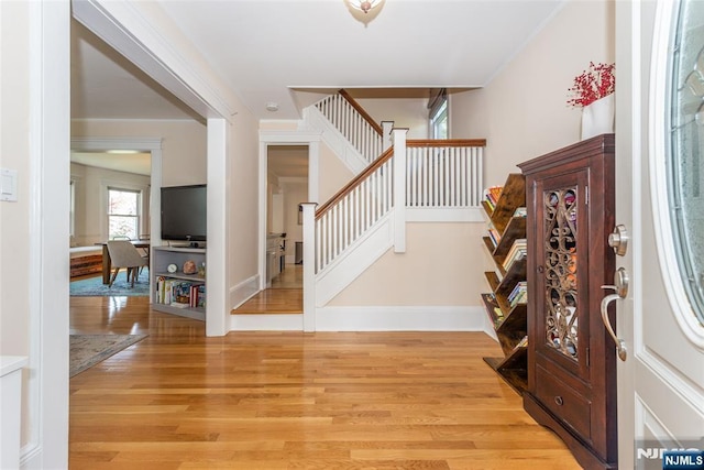entrance foyer with stairs, baseboards, and light wood finished floors