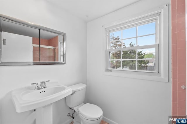 bathroom featuring baseboards, a sink, and toilet
