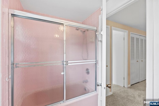 bathroom featuring a closet and shower / bath combination with glass door