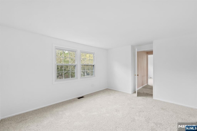 unfurnished room featuring visible vents, carpet flooring, and baseboards