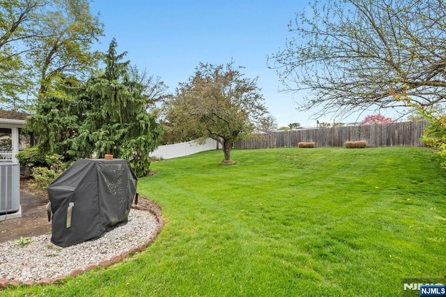view of yard featuring a fenced backyard and central AC