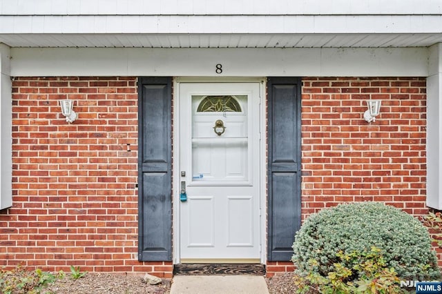doorway to property featuring brick siding