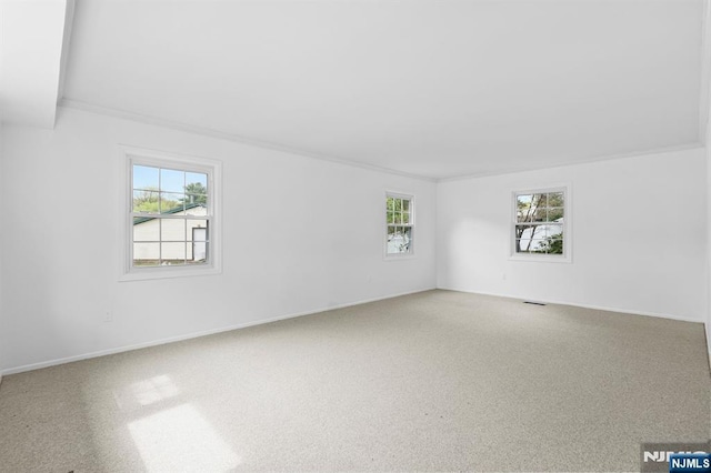 unfurnished room featuring crown molding, baseboards, and visible vents