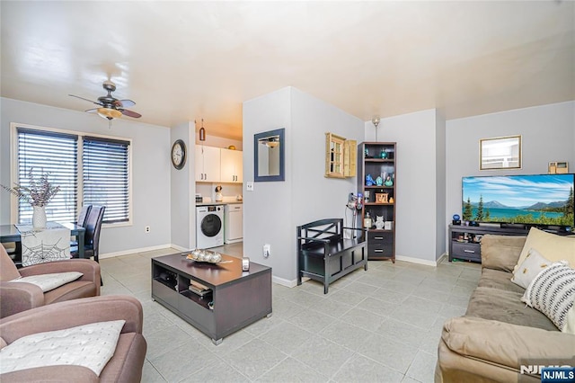 living area with washer / dryer, baseboards, and ceiling fan