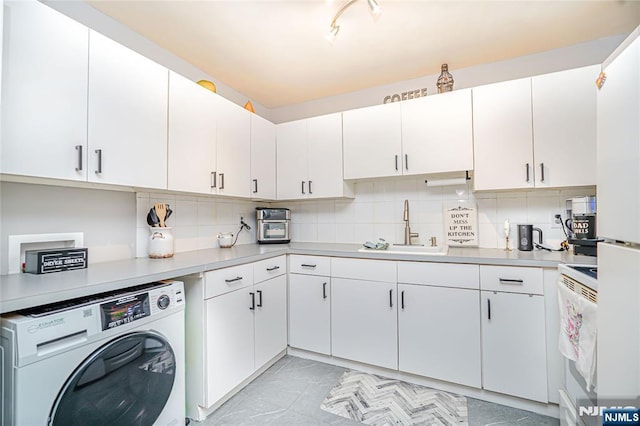 washroom with washer / clothes dryer, laundry area, and a sink