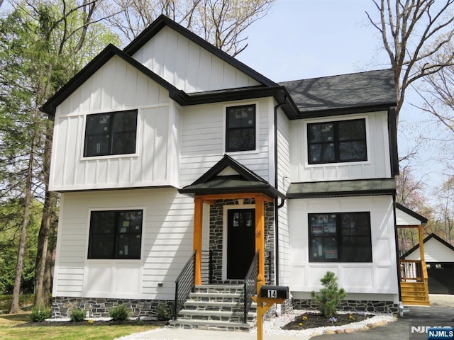modern inspired farmhouse with board and batten siding, a shingled roof, and entry steps