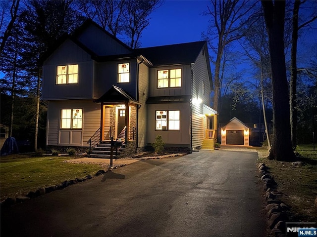 view of front of house featuring an outbuilding, driveway, and entry steps