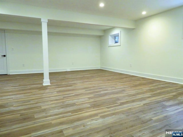 finished below grade area featuring baseboards, recessed lighting, and wood finished floors