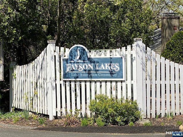 community / neighborhood sign featuring fence