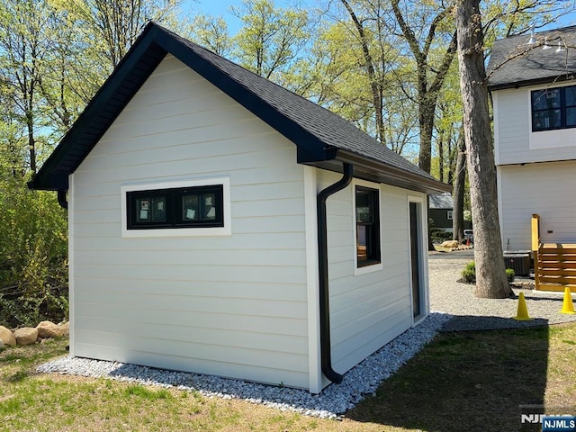view of outdoor structure with cooling unit and an outbuilding