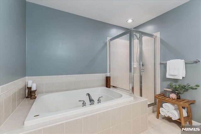 bathroom with tile patterned flooring, a shower stall, and a garden tub