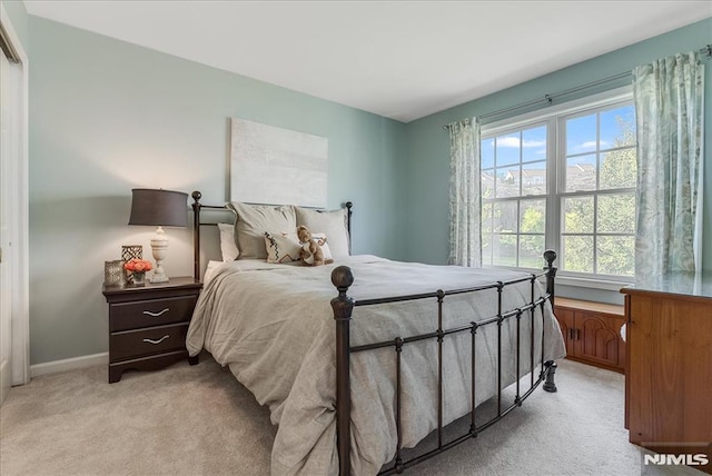 bedroom featuring baseboards and light carpet