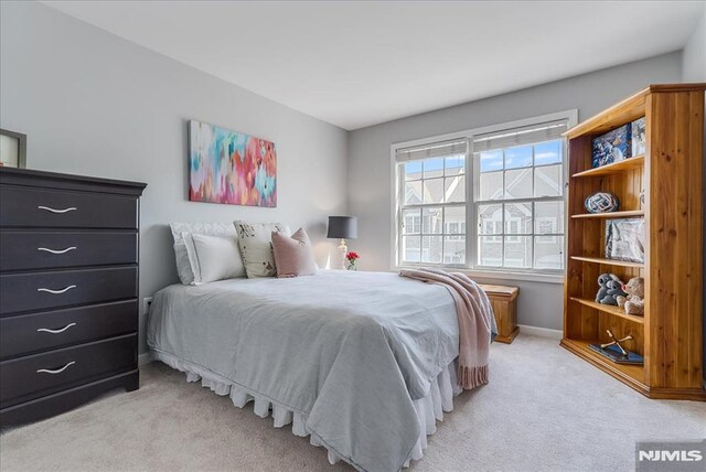 bedroom featuring baseboards and light colored carpet