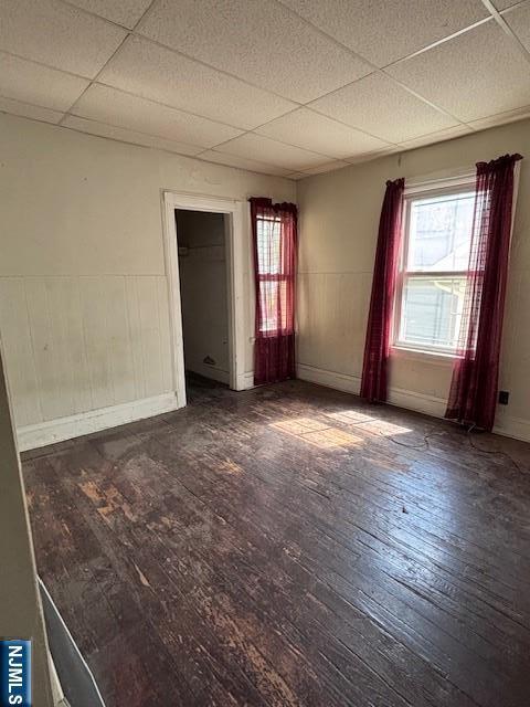 1 Reid Ave, Passaic, NJ 07055 - unfurnished bedroom with baseboards, a drop ceiling, hardwood / wood-style flooring, and a wainscoted wall