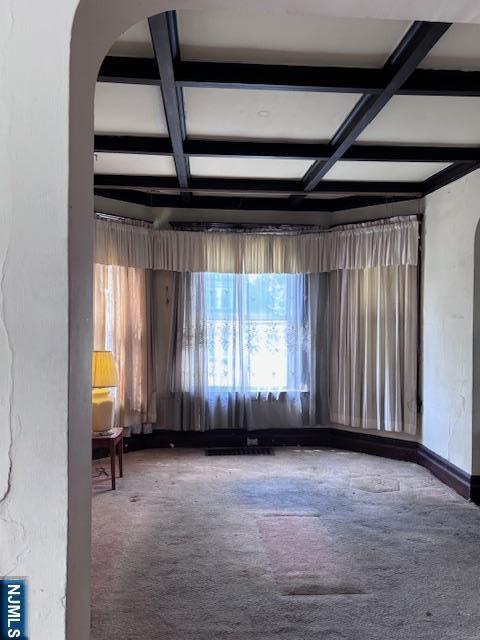 1 Reid Ave, Passaic, NJ 07055 - spare room featuring carpet floors, beam ceiling, baseboards, arched walkways, and coffered ceiling