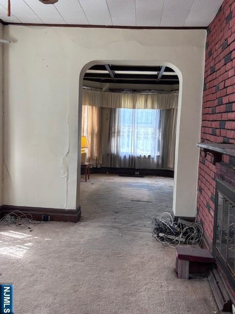 1 Reid Ave, Passaic, NJ 07055 - unfurnished living room with carpet flooring, arched walkways, and brick wall
