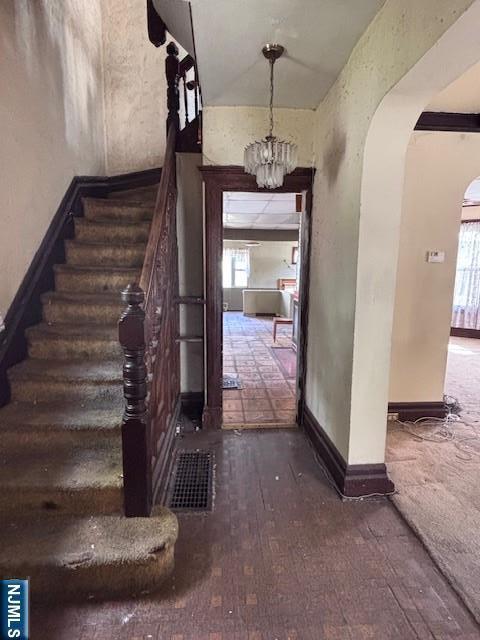 1 Reid Ave, Passaic, NJ 07055 - foyer entrance with an inviting chandelier, visible vents, stairs, baseboards, and arched walkways