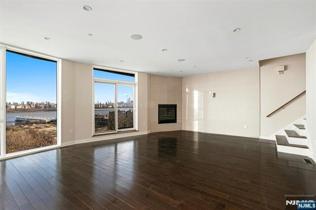5-05 Washington Pl Unit 5-05, Cliffside Park, NJ 07010 - unfurnished living room with stairs, wood finished floors, and a tile fireplace