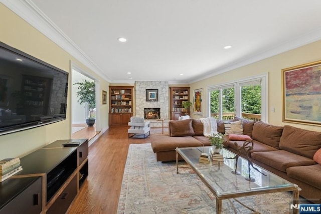 living room with crown molding, a fireplace, built in shelves, wood finished floors, and recessed lighting