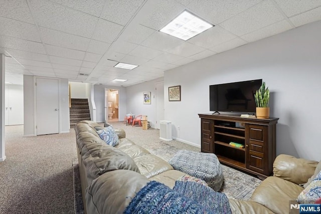carpeted living room with stairs, baseboards, and a paneled ceiling