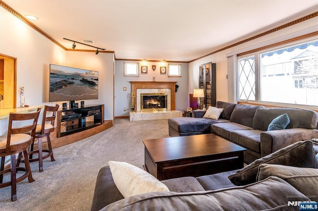 living room featuring crown molding, a high end fireplace, carpet, and visible vents