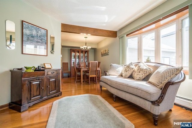 living room featuring light wood-style floors, an inviting chandelier, and baseboard heating