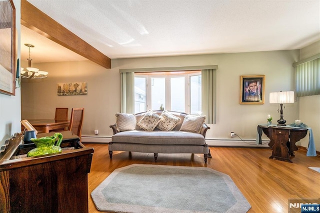 living area with an inviting chandelier, wood finished floors, baseboard heating, and beam ceiling
