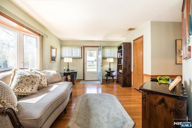 living area with visible vents and wood finished floors