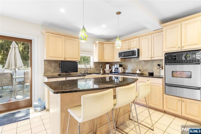 kitchen with tasteful backsplash, a sink, a warming drawer, light brown cabinets, and stainless steel appliances