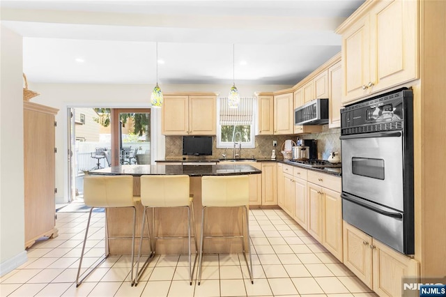 kitchen with decorative backsplash, appliances with stainless steel finishes, light brown cabinetry, a sink, and a warming drawer