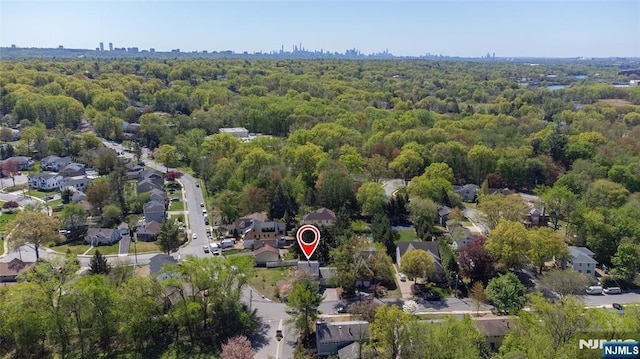 drone / aerial view featuring a forest view and a residential view