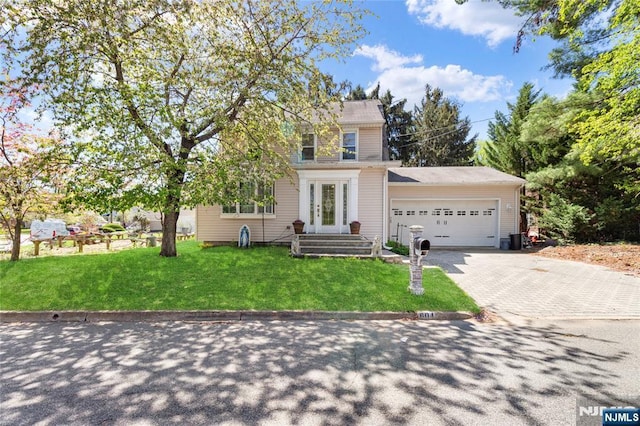 traditional-style home with an attached garage, driveway, and a front yard