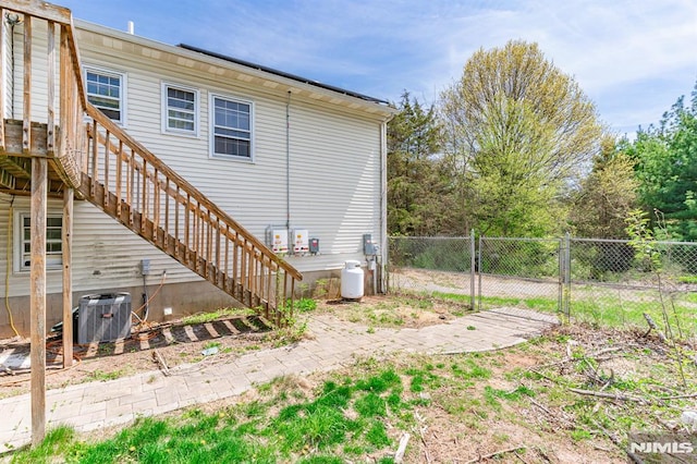 back of property with fence and central AC unit