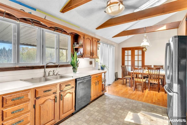 kitchen featuring a sink, light countertops, freestanding refrigerator, lofted ceiling with beams, and black dishwasher