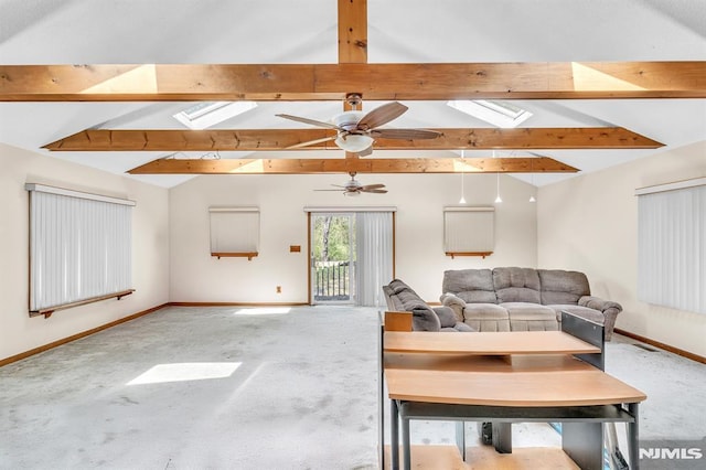 carpeted living area featuring vaulted ceiling with skylight, baseboards, and a ceiling fan