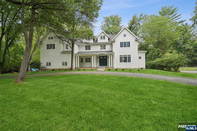 view of front of property with crawl space, aphalt driveway, covered porch, and a front yard