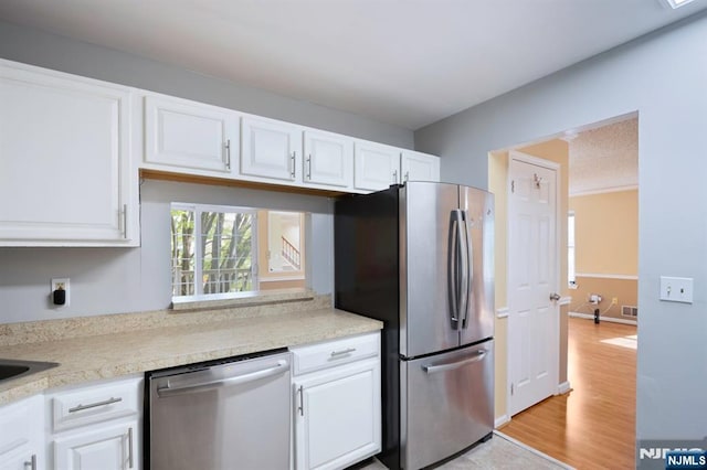 kitchen featuring light countertops, appliances with stainless steel finishes, and white cabinets