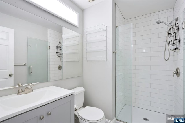 full bathroom with toilet, a shower stall, and vanity