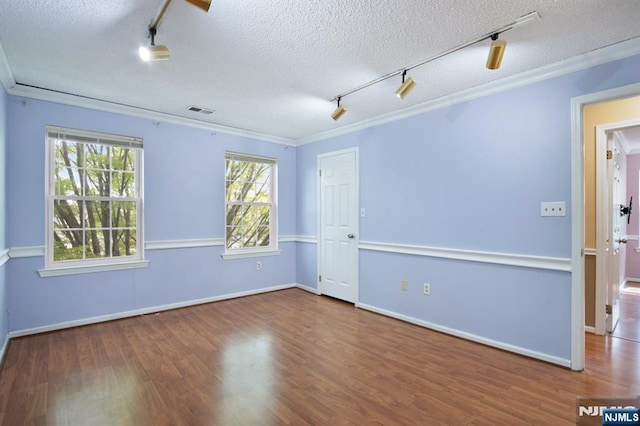 unfurnished room featuring crown molding, a textured ceiling, track lighting, and wood finished floors
