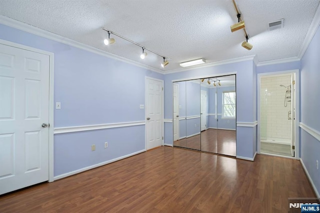 unfurnished bedroom with an inviting chandelier, ornamental molding, rail lighting, and visible vents