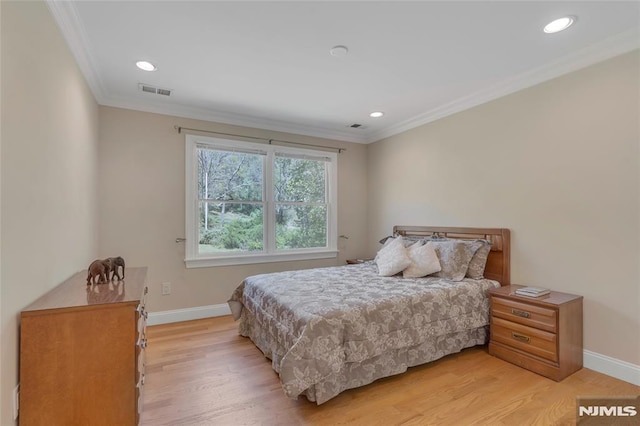 bedroom with crown molding, baseboards, and light wood-style flooring