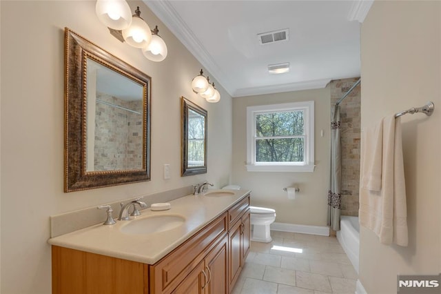 bathroom featuring crown molding, double vanity, visible vents, and a sink